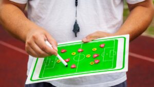 A beginner learning how to play football, practicing dribbling with a soccer ball on a field.