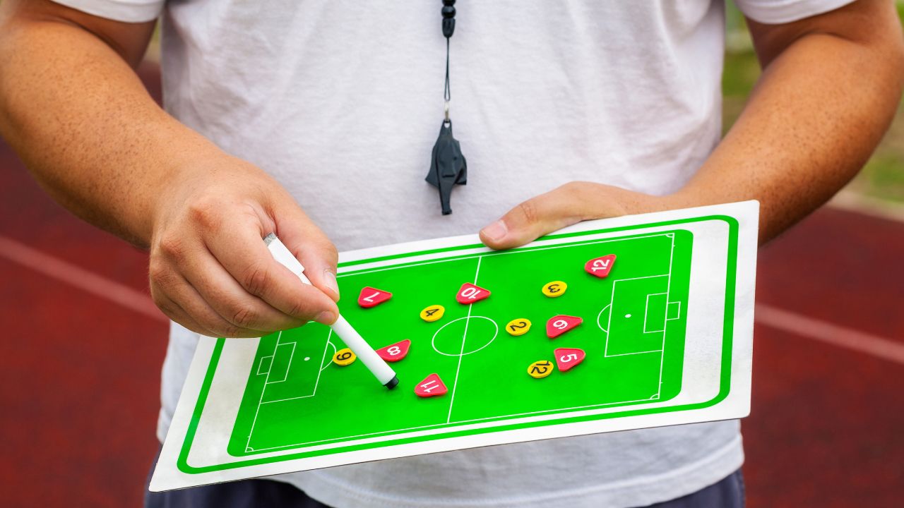 A beginner learning how to play football, practicing dribbling with a soccer ball on a field.