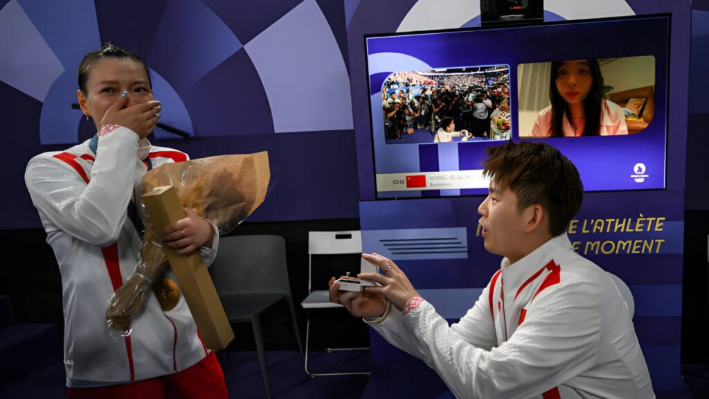 China's Liu Yuchen proposes to his partner and gold medalist Huang Ya Qiong after leaving the podium at the mixed doubles badminton medal ceremony at the Paris 2024 Olympic Games at Porte de la Chapelle Arena on August 2, 2024. ARUN SANKAR/AFP / "AFP systems have changed this photo's metadata's incorrect mention[s]: Correction: Liu Yuchen from Zheng Siwei. Please delete the incorrect mention(s) from all your internet services and servers immediately. AFP has permitted you to distribute it (them) to third parties; please ensure they do the same. You are responsible for any post-notification use if you do not comply immediately. Please accept our gratitude for your swift attention and action. We apologize for any trouble this notification may create and are available for more information." ARUN SANKAR/AFP/Getty Images