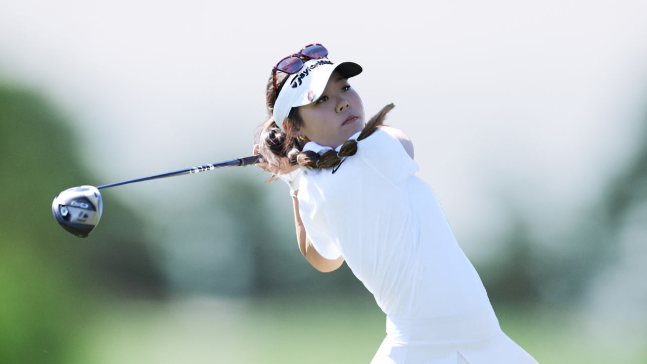 Jasmine Koo posing confidently on the golf course, showcasing her talent as a rising star in American golf.