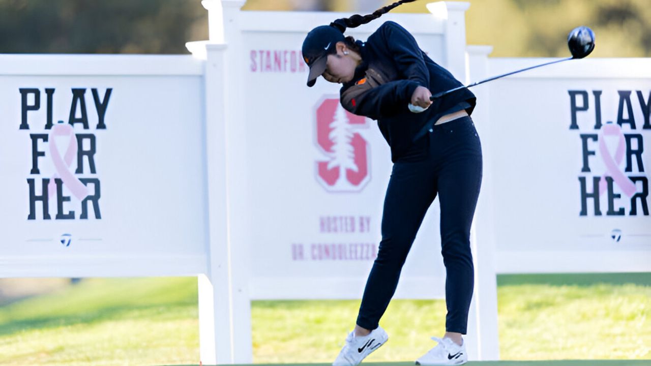 Jasmine Koo posing with her golf club at USC's golf course.