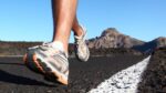 Variety of running shoes displayed on a wooden surface, showcasing popular brands for runners.